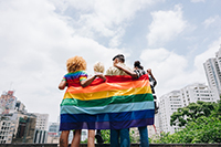 people draped in lgbtq pride flag